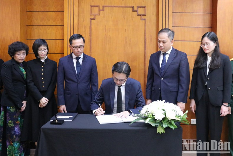 El viceministro Do Hung Viet firma el libro de condolencias en memoria del secretario general Nguyen Phu Trong.
