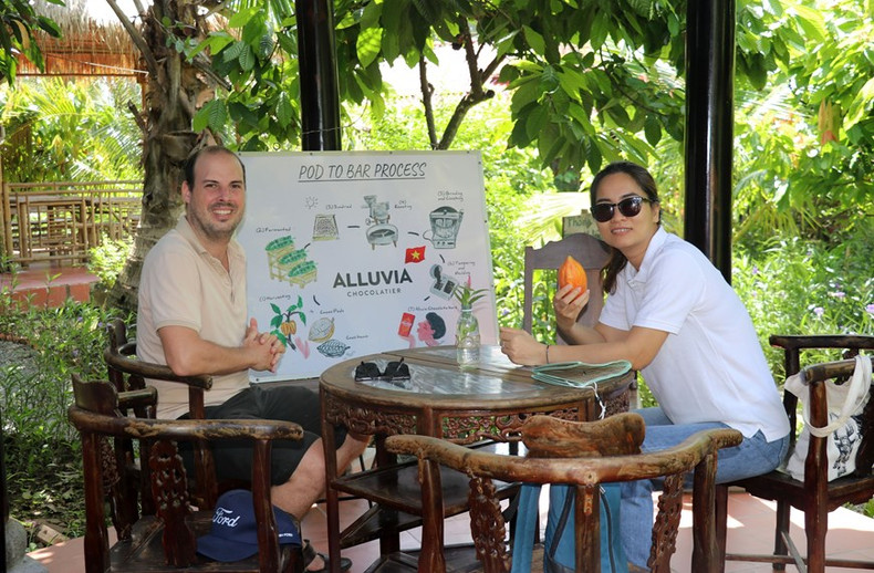 Turistas extranjeros visitan el huerto de cacao y la fábrica de chocolate. Foto: VNA