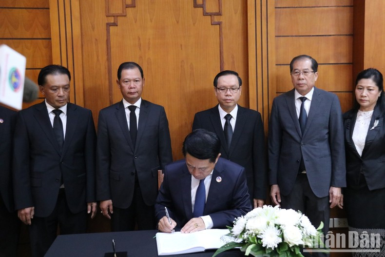 El vicepremier y el ministro de Asuntos Exteriores de Laos, Saleumxay Kommasith, firma el libro de condolencias.