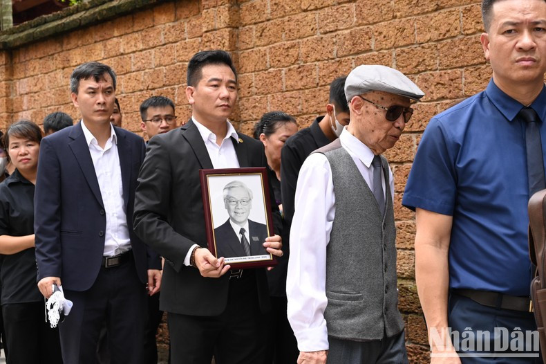 Muchas personas portan retrato del secretario general Nguyen Phu Trong.