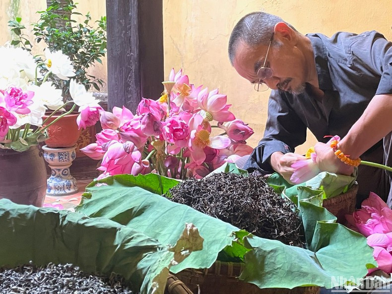 El artista de elaborar el té del loto Dam Quang Minh presenta la técnica de marinar el té de loto. El artista de elaborar el té del loto Dam Quang Minh presenta la técnica de marinar el té de loto.