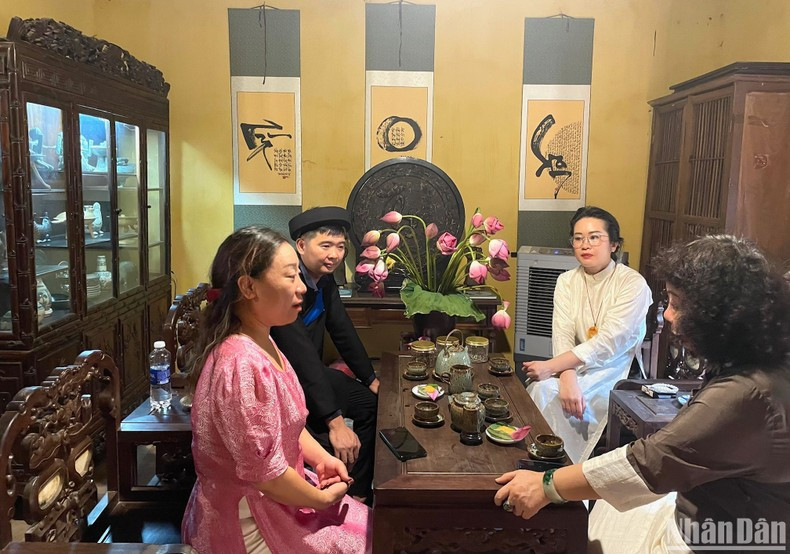 Visitantes disfrutan del té marinado de loto de Hanói. Visitantes disfrutan del té marinado de loto de Hanói.