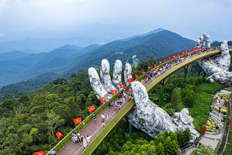 En ocasión del Día Nacional de Vietnam, el conjunto turístico Sun World Ba Na Hills se decora con 100 banderas nacionales, colocadas a lo largo del Puente Dorado con una longitud de 148,6 metros. (Foto: VNA)