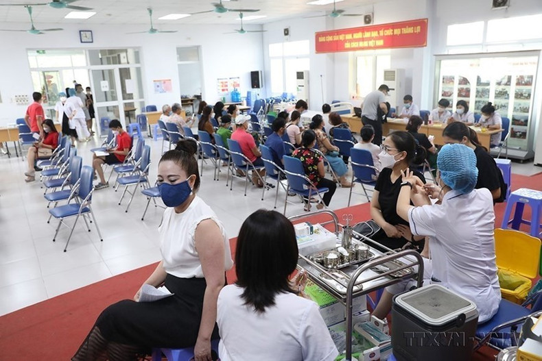 Con el fin de cubrir rápidamente la vacuna contra el Covid-19 y limitar la propagación de la epidemia, los centros de salud del distrito de Hanói han acelerado la vacunación contra el Covid-19, especialmente las terceras y cuartas dosis para personas (agosto de 2022). (Foto: VNA) Con el fin de cubrir rápidamente la vacuna contra el Covid-19 y limitar la propagación de la epidemia, los centros de salud del distrito de Hanói han acelerado la vacunación contra el Covid-19, especialmente las terceras y cuartas dosis para personas (agosto de 2022). (Foto: VNA)