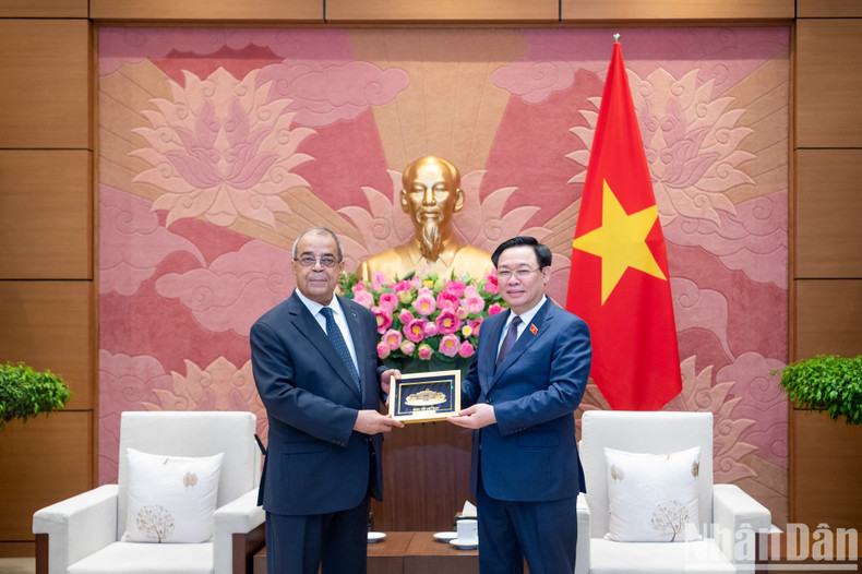 Vuong Dinh Hue entrega un regalo de recuerdo al funcionario argelino.