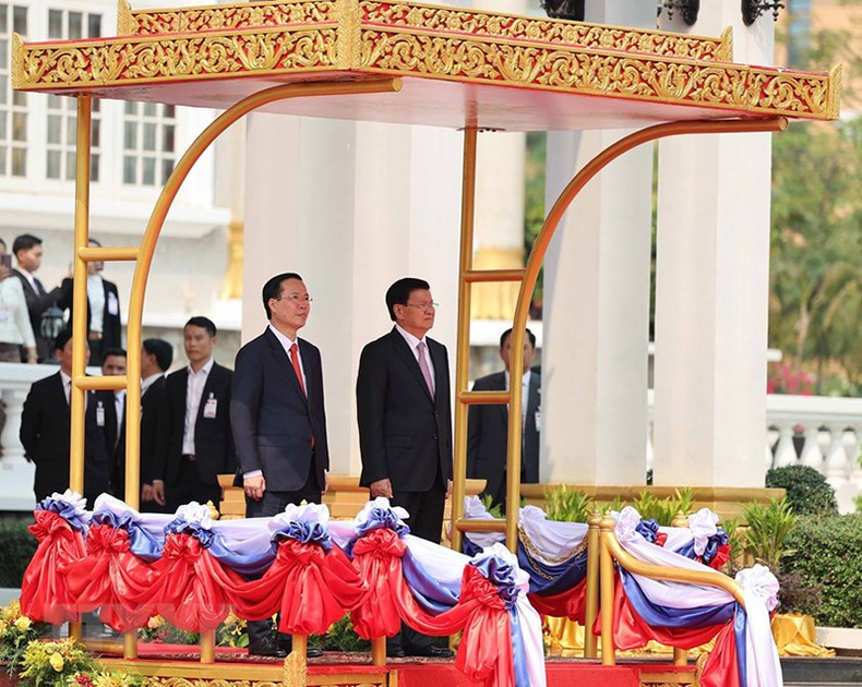 El secretario general PPRL y presidente de Laos, Thongloun Sisoulith, y el presidente Vo Van Thuong realizan acto del saludo a la bandera.