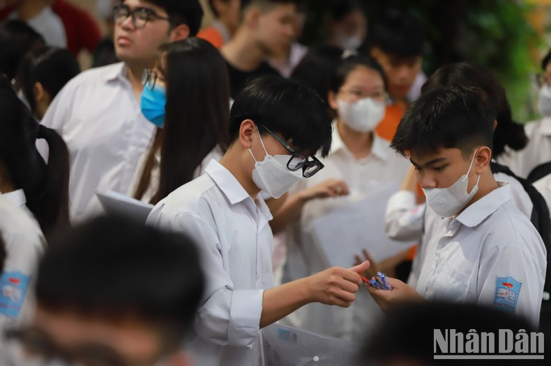 Estudiantes revisan sus bolígrafos antes de entrar en la sala de examen.