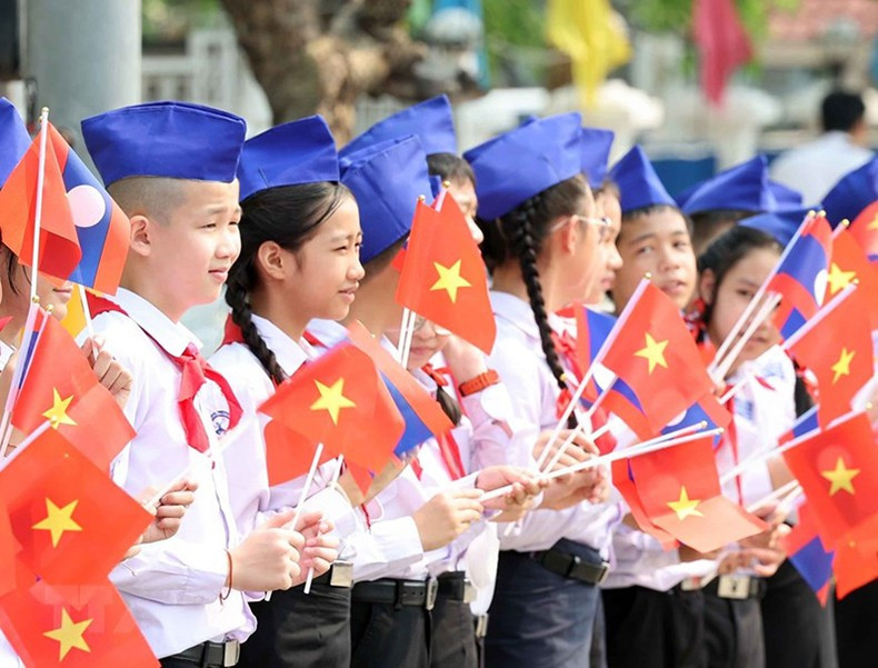 Niños en Vientián dan la bienvenida al mandatario vietnamita.