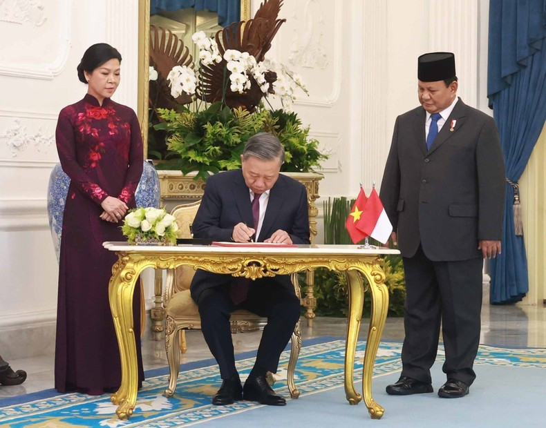 El máximo líder partidista de Vietnam, To Lam, firma el libro de recuerdo.