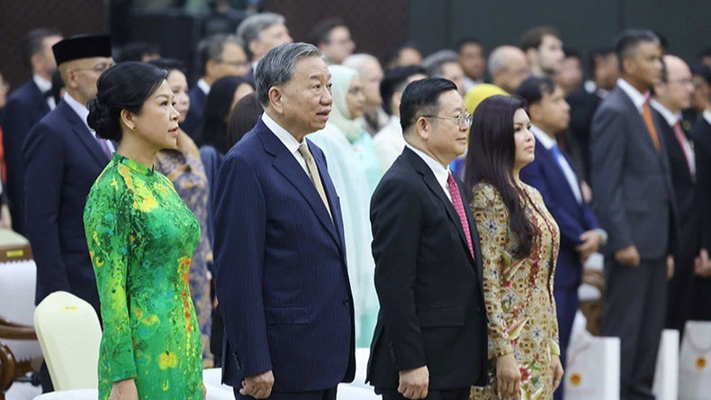 El máximo dirigente partidista de Vietnam, To Lam, y su esposa, y el secretario general de la Asean, Kao Kim Hourn y su cónyuge realizan el acto de saludo a la bandera de la Asean.
