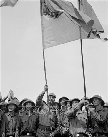 El primer secretario del Comité Central del Partido Comunista de Cuba y primer ministro del Gobierno Revolucionario, Fidel Castro, enarbola con orgullo la bandera tradicional de la Brigada Khe Sanh, del Ejército de Liberación de Tri Thien - Hue (Quang Tri, 15 de septiembre de 1973). Foto: VNA El primer secretario del Comité Central del Partido Comunista de Cuba y primer ministro del Gobierno Revolucionario, Fidel Castro, enarbola con orgullo la bandera tradicional de la Brigada Khe Sanh, del Ejército de Liberación de Tri Thien - Hue (Quang Tri, 15 de septiembre de 1973). Foto: VNA
