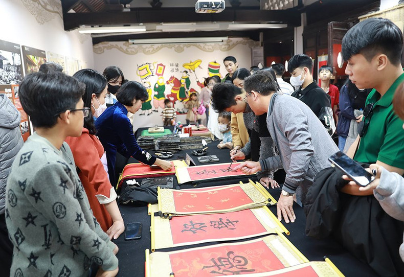 Los turistas aprenden a escribir su propia caligrafía para la buena suerte al comienzo del Año Nuevo. Los turistas aprenden a escribir su propia caligrafía para la buena suerte al comienzo del Año Nuevo.
