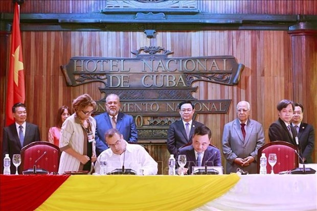 El presidente de la Asamblea Nacional, Vuong Dinh Hue, y el primer ministro cubano, Manuel Marrero Cruz, presencian la firma de acuerdos entre empresarios de Vietnam y Cuba. (Fotografía: VNA)