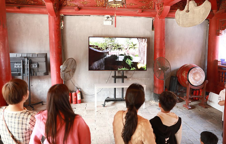 Visitantes aprenden sobre el Templo de la Literatura mediante un documental. Visitantes aprenden sobre el Templo de la Literatura mediante un documental.