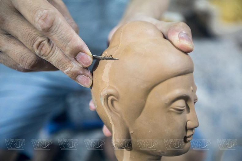 Artesano trabaja la imagen de Buda para darle una forma más adecuada.