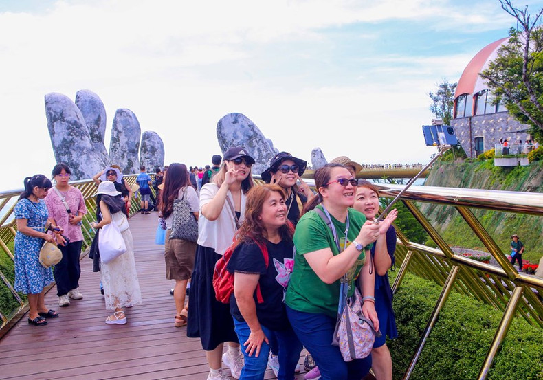 Turistas internacionales pasean con entusiasmo por el Puente Dorado, en el área turística Sun World Ba Na Hills. Turistas internacionales pasean con entusiasmo por el Puente Dorado, en el área turística Sun World Ba Na Hills.