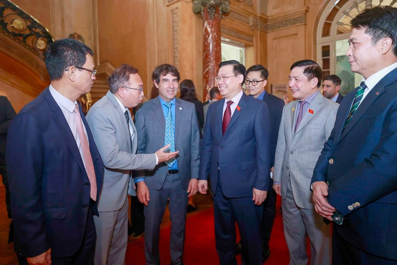 Vuong Dinh Hue entre los delegados de ambos países.