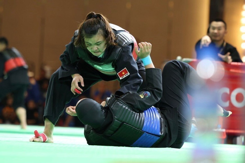 Quang Thi Thu Nghia, (cinturón rojo, derecha) derrotó a Nia Larasati de Indonesia (cinturón azul) en la ronda final de Pencak Silat, en la categoría de lucha de 65-70 kg, para llevar una presea dorada a la selección vietnamita.