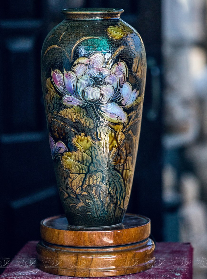 Hojas y flores de loto en jarrón de cerámica.