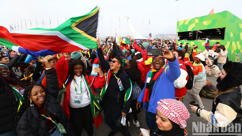 El desfile comienza con un grupo de tambores y enmascarados caminando sobre zancos.