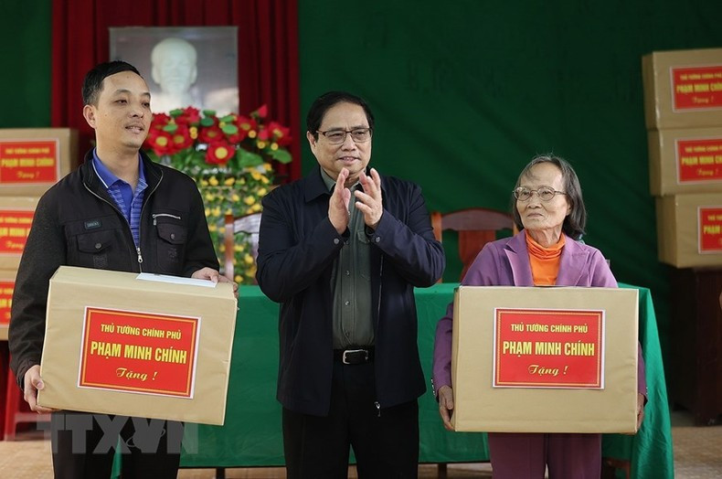 Pham Minh Chinh entrega regalos a las familias reasentadas por el desbroce del terreno para la autopista Norte-Sur.