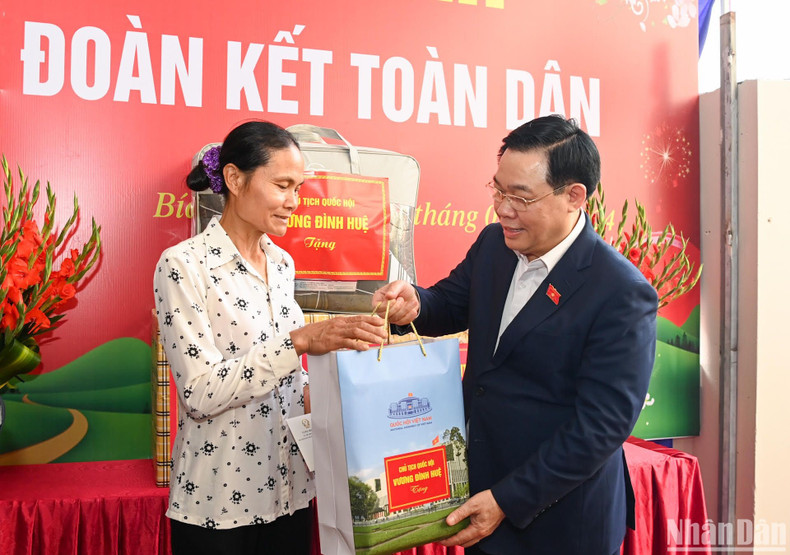 Vuong Dinh Hue entrega regalos a la delegada Le Thi Chinh.