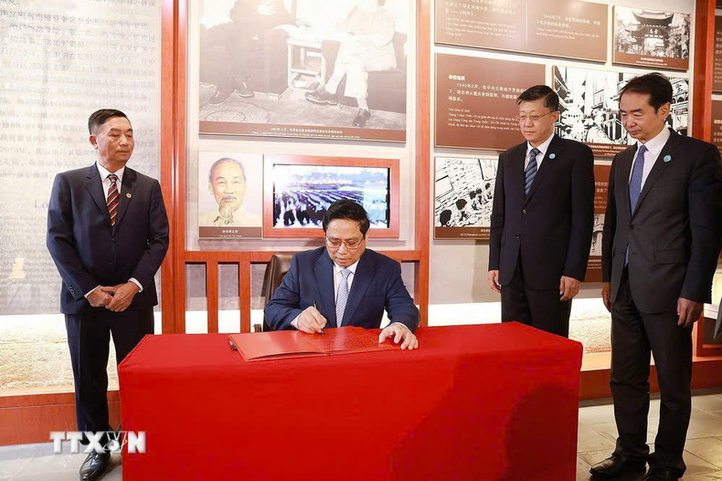 El premier vietnamita escribe en el libro de recuerdos en la zona de reliquias. (Foto: VNA) El premier vietnamita escribe en el libro de recuerdos en la zona de reliquias. (Foto: VNA)