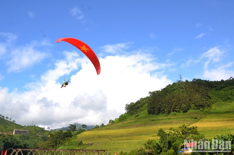 Turistas disfrutan de un vuelo en parapente sobre el valle de Muong Hum. Turistas disfrutan de un vuelo en parapente sobre el valle de Muong Hum.