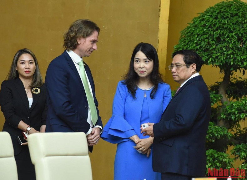 El primer ministro, Pham Minh Chinh, conversa con los delegados.