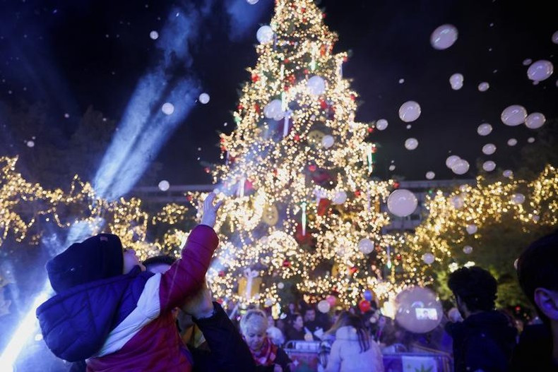 Un niño disfruta de la ceremonia de iluminación del árbol de Navidad en Atenas, Grecia, el 1 de diciembre de 2022. (Fotografía: Reuters)