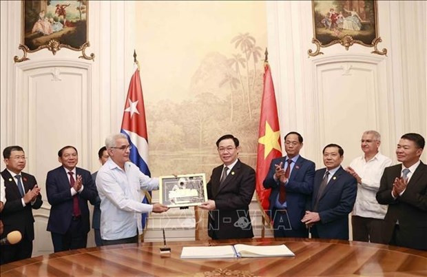 El presidente de la Asamblea Nacional de Vietnam, Vuong Dinh Hue, obsequia al Centro un cuadro de símbolo de la sede del Parlamento vietnamita. (Foto: VNA) El presidente de la Asamblea Nacional de Vietnam, Vuong Dinh Hue, obsequia al Centro un cuadro de símbolo de la sede del Parlamento vietnamita. (Foto: VNA)