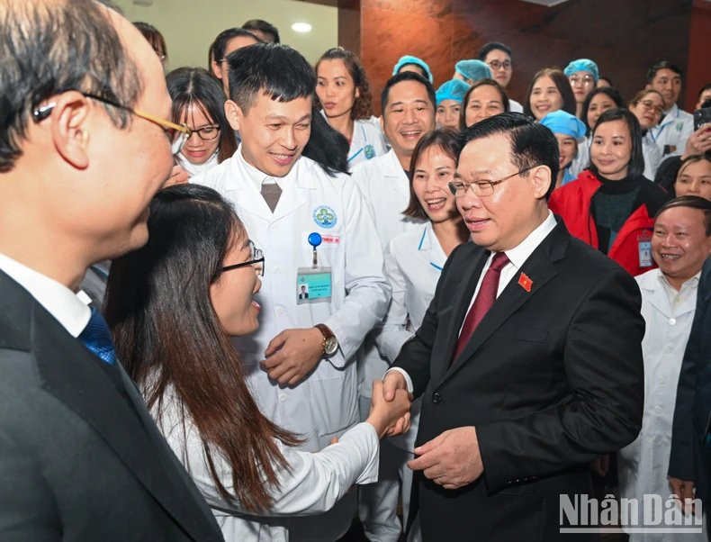 El presidente de la AN, Vuong Dinh Hue, con médicos y las enfermeras del Hospital General del distrito de Dinh Hoa.