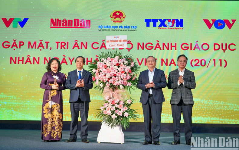 Los líderes de la VOV entregan flores a trabajadores del sector educativo.