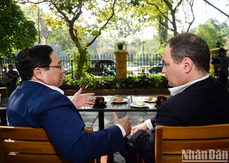 Minh Chinh y Roman Golovchenko disfrutan de un café y admiran las calles de Hanói.