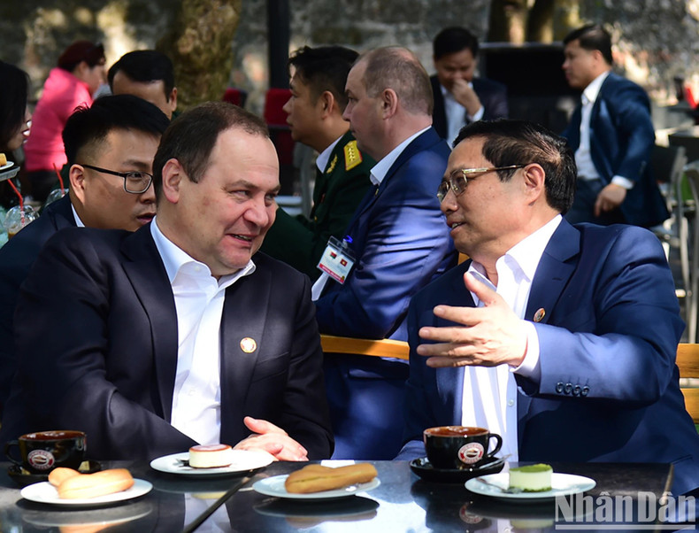 Los dos primeros ministros conversan mientras toman café vietnamita en la cafetería situada al pie de la Torre de Bandera de Hanói, en la calle Dien Bien Phu.