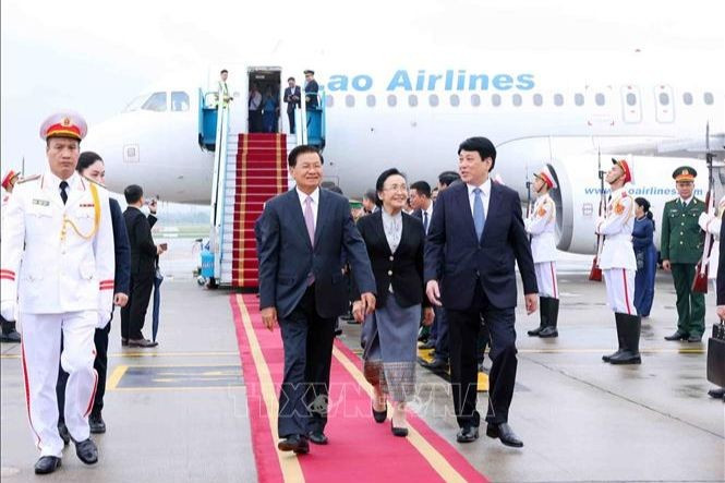 El secretario general del PPRL, Thongloun Sisoulith, y su esposa, arriban a Hanói para iniciar su visita de Estado a Vietnam. (Foto: VNA)