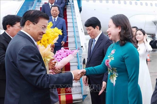 La vicepresidenta vietnamita Vo Thi Anh Xuan da la bienvenida a Thongloun Sisoulith, y a su esposa en el aeropuerto internacional de Noi Bai. (Foto: VNA)