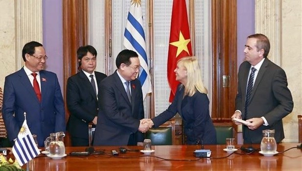 El presidente de la Asamblea Nacional de Vietnam, Vuong Dinh Hue (tercera persona desde la izquierda), y la titular del Senado uruguayo, Beatriz Argimon, en la ceremonia de firma del acuerdo entre ambos órganos legislativos. (Foto: VNA)