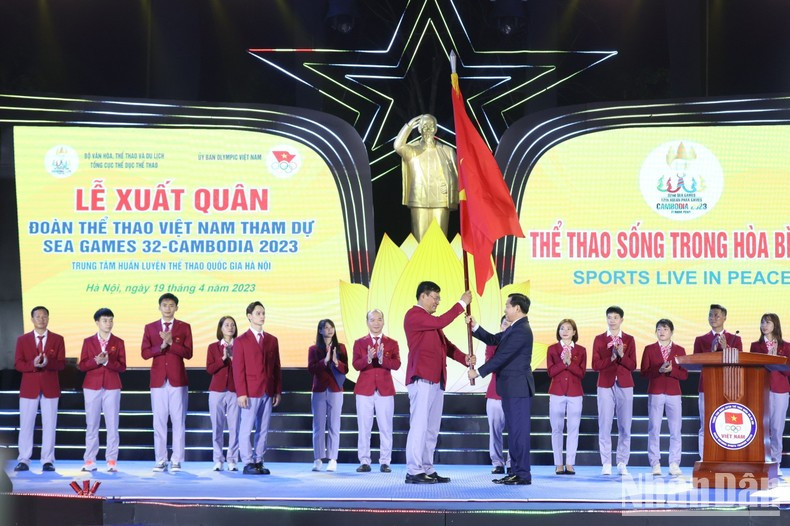 El viceprimer ministro Le Minh Khai entrega la bandera al jefe de la delegación de deportes de Vietnam, Dang Ha Viet.
