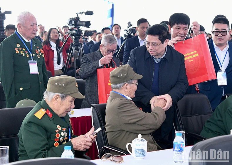 El primer ministro Pham Minh Chinh entrega obsequios a los veteranos asistentes en la actividad. (Foto: Nhan Dan)