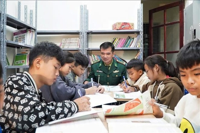 Nguyen Van Tham, del puesto de guardia fronterizo de Mon Son, guía a los alumnos en sus estudios. (Foto: Distribuida por VNA)