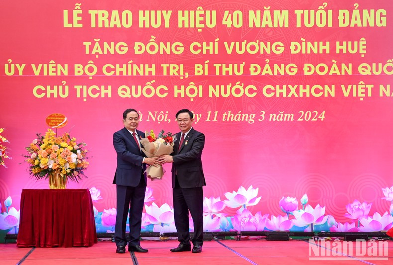 El vicepresidente permanente de la AN, Tran Thanh Man, entrega flores para felicitar a Dinh Hue.
