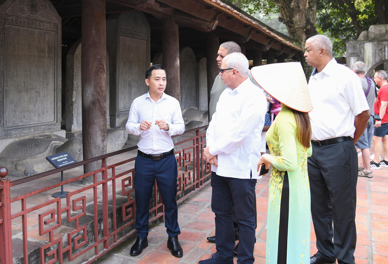 Los visitantes escuchan una explicación del significado del conjunto de 82 estelas de piedra en las que están tallados los nombres de los doctorados conservados en el Templo de la Literatura. (Foto: quochoi.vn) Los visitantes escuchan una explicación del significado del conjunto de 82 estelas de piedra en las que están tallados los nombres de los doctorados conservados en el Templo de la Literatura. (Foto: quochoi.vn)