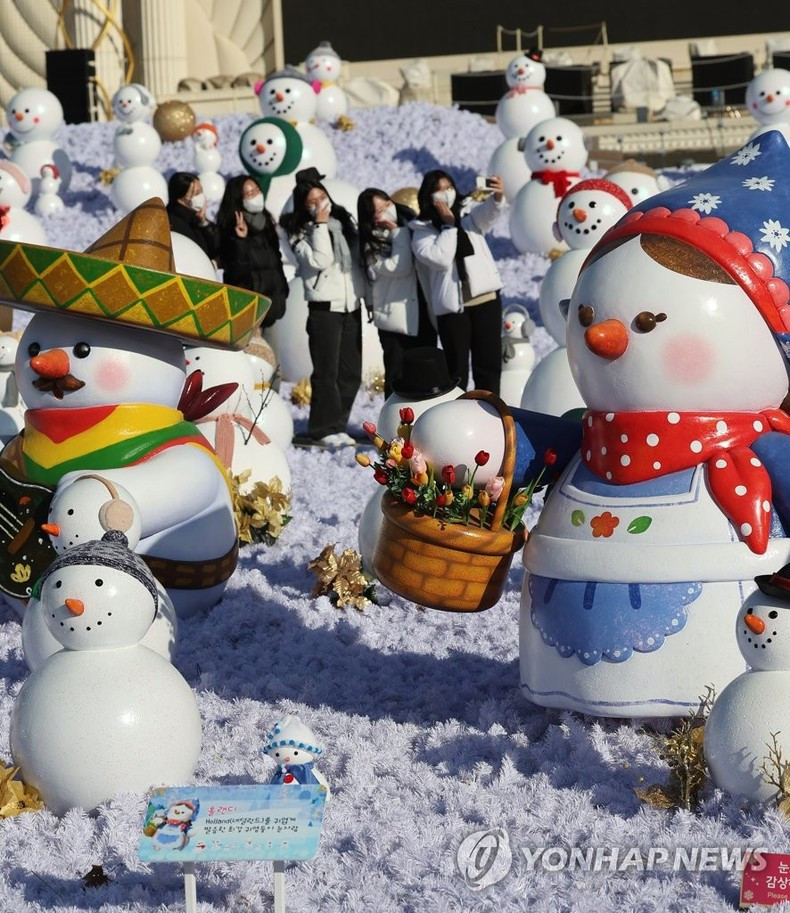 Jóvenes toman fotos en el espacio Snowman World, que muestra más de dos mil muñecos de nieve, en el Parque de Everland, a unos 40 kilómetros al sur de Seúl, Corea del Sur. (Fotografía: Yonhap)