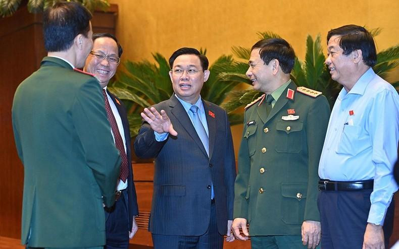 El presidente de la Asamblea Nacional, Vuong Dinh Hue, y los otros delegados al margen de la sesión de debate sobre el proyecto de Ley de Defensa Civil.