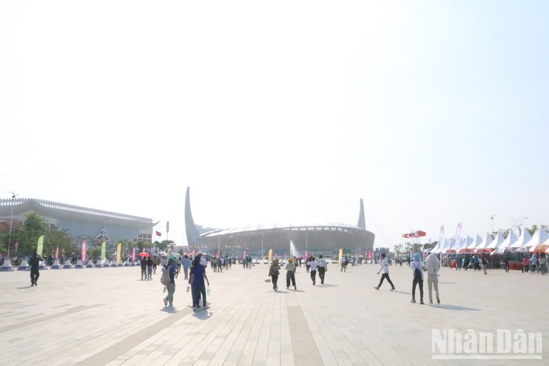 Los espectadores cruzan el espacio grande frente del estadio para llegar a la entrada