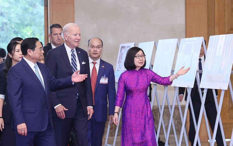 La subdirectora general de la Agencia Vietnamita de Noticias (VNA), Doan Thi Tuyet Nhung, presenta obras fotográficas al primer ministro Pham Minh Chinh y al presidente estadounidense Joe Biden, en una exposición realizada por la VNA (11 de septiembre de 2023). (Foto: VNA)