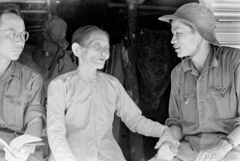 El periodista Duong Thanh Phong (con gorra), de la Agencia Informativa de Liberación en Quang Tri, conversa con la señora Chat, quien albergaba a cuadros revolucionarios en la ciudad de Quang Tri. (Foto: VNA)