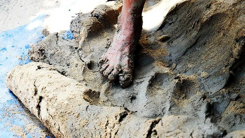 Se amasan ingredientes de arcilla, arena y agua.