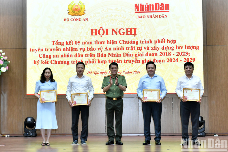 El teniente general Luong Tam Quang, ministro de Seguridad Pública, otorga la medalla "Protección de la seguridad nacional" a los directivos de Nhan Dan.